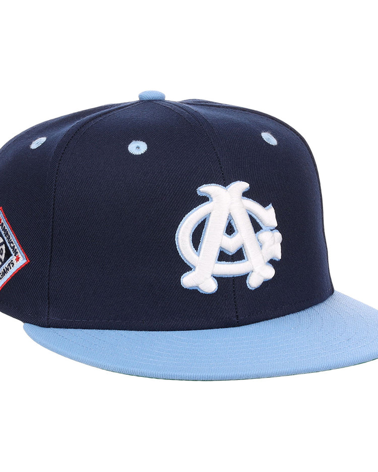 The EFF Chicago American Giants NLB Flip Fitted Ballcap is a navy blue, vintage-inspired hat with a light blue brim, featuring a white AC logo on the front and a red, white, and blue patch on the side.