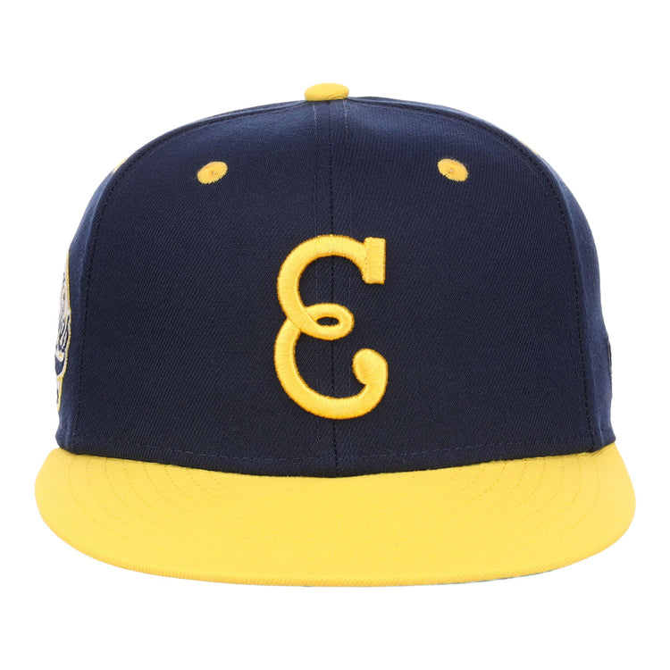 The EFF Newark Eagles NLB Flip Fitted Ballcap features a navy design with a yellow brim and button, highlighted by a bold yellow C on the front, honoring the legacy of the Negro National League.