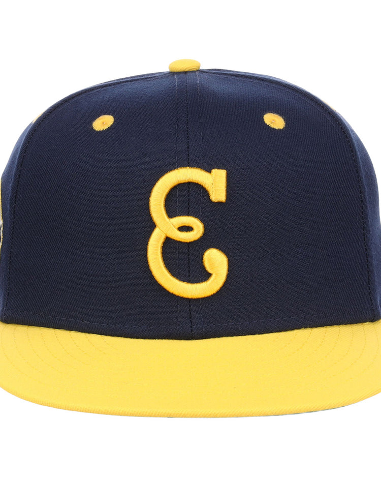 The EFF Newark Eagles NLB Flip Fitted Ballcap features a navy design with a yellow brim and button, highlighted by a bold yellow C on the front, honoring the legacy of the Negro National League.