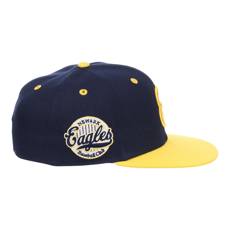 The EFF Newark Eagles NLB Flip Fitted Ballcap is a navy and yellow cap with a yellow brim, featuring an embroidered side patch reading Newark Eagles Baseball Club, honoring the Negro National League legacy.