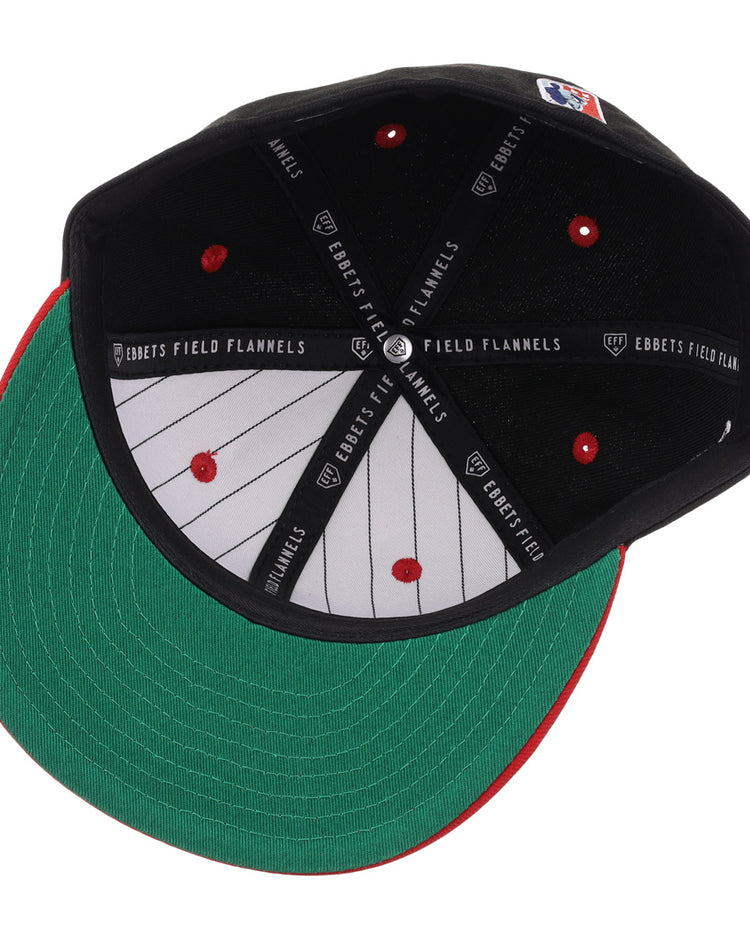 A top-down view of the inside of an EFF Philadelphia Stars NLB Flip Fitted Ballcap shows red stitching, a green brim underside, pinstripe lining, and EBBETS FIELD FLANNELS branding on the inner bands.