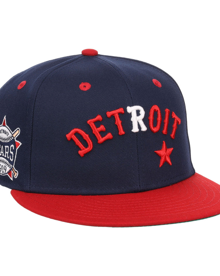 The EFF Detroit Stars NLB Flip Fitted Ballcap features a navy blue crown, red brim, DETROIT in red and white letters, a red star, and a Detroit Stars 1919 side patch—vintage style honoring the Negro National League.
