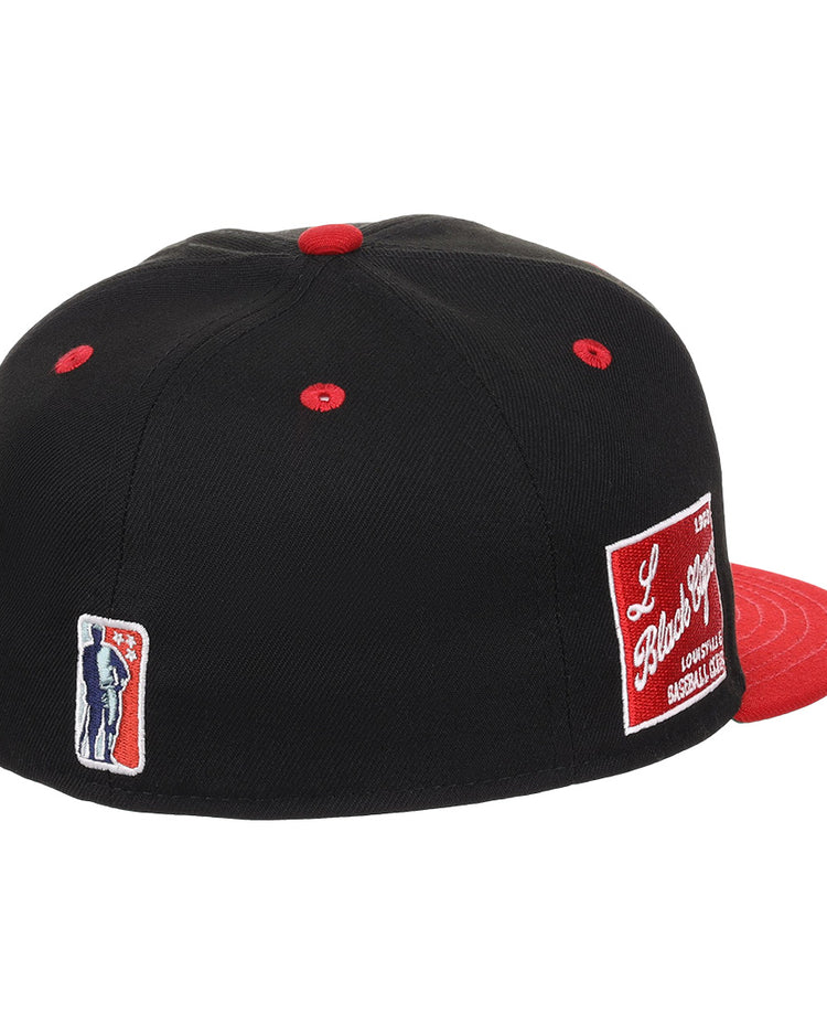 The EFF Louisville Black Caps NLB Flip Fitted Ballcap is a vintage-inspired black cap with a red brim and button, featuring two heritage patches—including one honoring the Negro National League team.