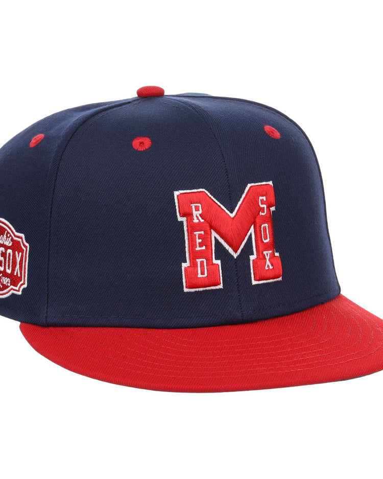The EFF Memphis Red Sox NLB Flip Fitted Ballcap features a navy blue and red design, large red M with white outline, “RED SOX” on the front, a side Memphis Red Sox patch honoring the Negro American League team, plus a red bill and button.