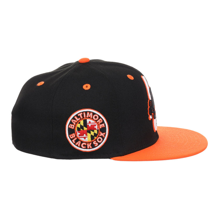 The EFF Baltimore Black Sox NLB Flip Fitted Ballcap features a black crown, orange brim and button, Maryland flag side patch, orange eyelets, Eastern Colored League embroidery, and vintage-inspired front detailing.