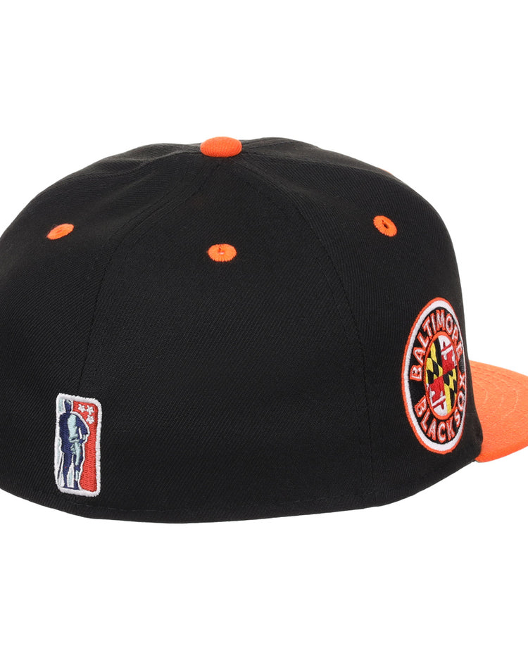 The EFF Baltimore Black Sox NLB Flip Fitted Ballcap features a black crown with orange accents, a round side patch honoring the teams Eastern Colored League legacy, and vintage-inspired style.