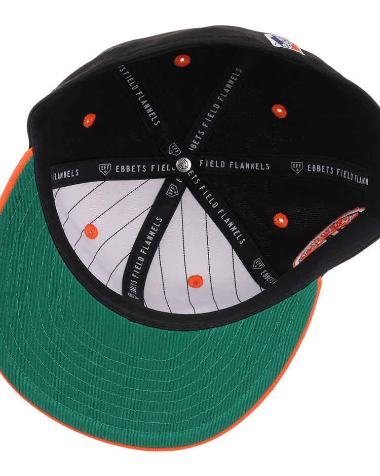 An overhead view of the EFF Baltimore Black Sox NLB Flip Fitted Ballcap reveals a green underbrim, black and orange interior, white pinstriped lining, and signature EFF branding—honoring the legacy of the Eastern Colored League.