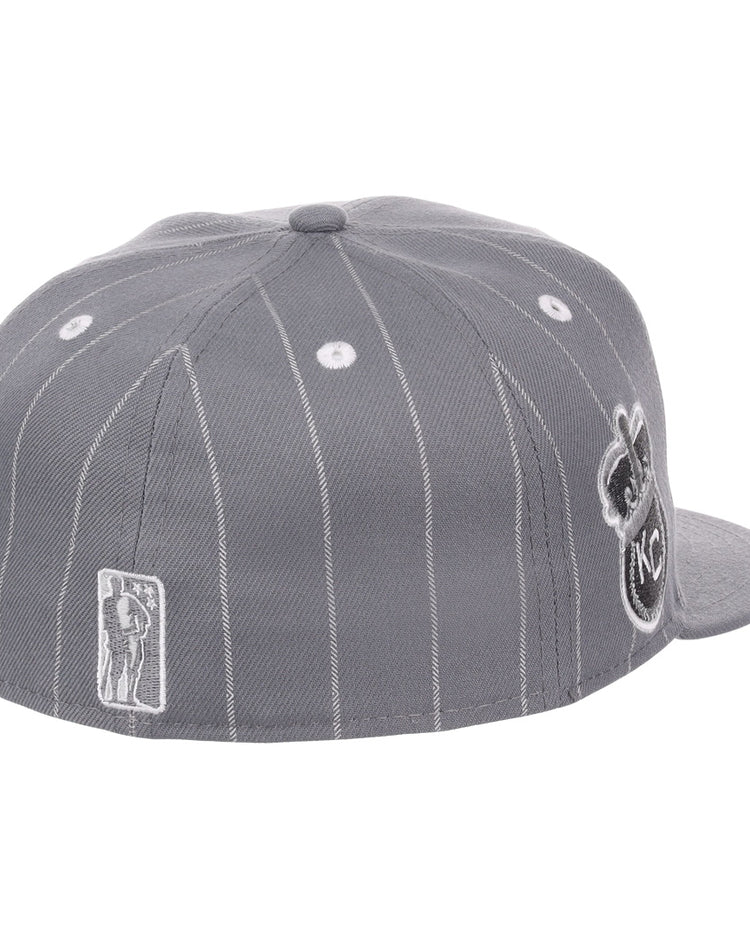 The EFF Kansas City Monarchs NLB Black Pinstripe Fitted Ballcap is shown from the back left, highlighting a small Monarchs player logo and a large circular KC logo on the side—celebrating Negro National League heritage.