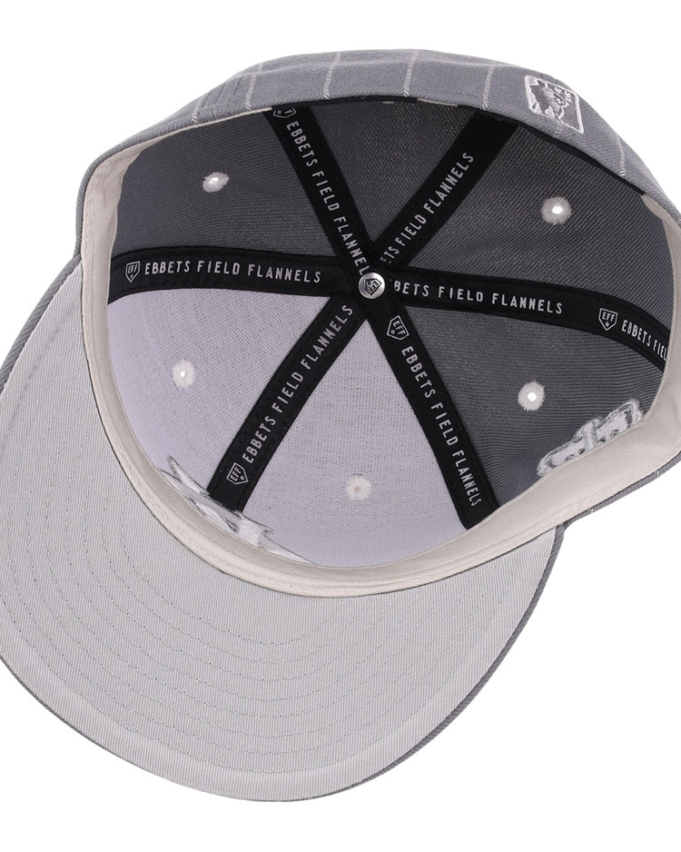 Top-down view of a Kansas City Monarchs NLB Black Pinstripe Fitted Ballcap by EFF, showing white stitched eyelets, black lining with “EBBETS FIELD FLANNELS” text, and a light gray underbill—honoring Negro National League heritage.