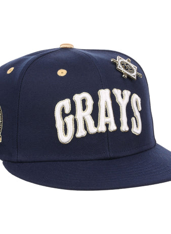 The EFF Homestead Grays Josh Gibson Fitted Ballcap in navy features “GRAYS” in large white letters, a team patch on the side, and a vintage baseball pin above the logo.