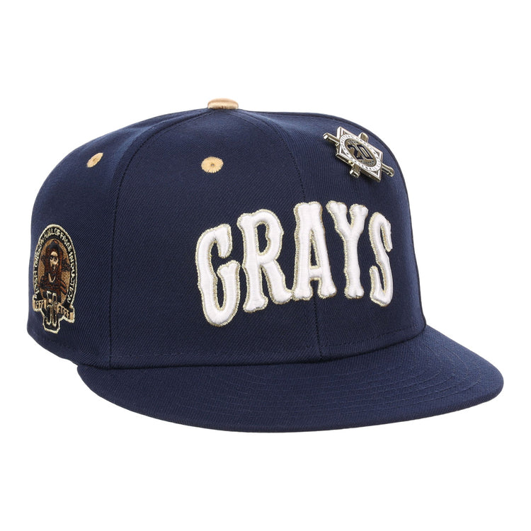 The EFF Homestead Grays Josh Gibson Fitted Ballcap in navy features “GRAYS” in large white letters, a team patch on the side, and a vintage baseball pin above the logo.