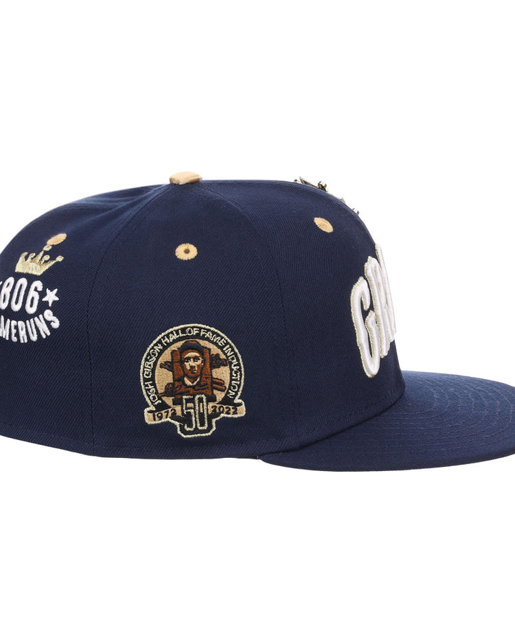 The EFF Homestead Grays Josh Gibson Fitted Ballcap in navy features 806 Home Runs with a crown graphic, a 50th Hall of Fame patch, and bold white embroidery, honoring Negro Leagues legend Josh Gibson. Limited edition.