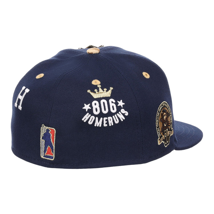 The EFF Homestead Grays Josh Gibson Fitted Ballcap in navy features embroidered patches: 806 Home Runs with a crown, a player silhouette, the letter H, and a round lion and laurel wreath patch.