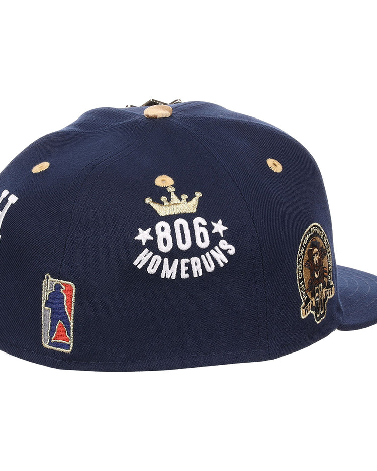 The EFF Homestead Grays Josh Gibson Fitted Ballcap in navy features embroidered patches: 806 Home Runs with a crown, a player silhouette, the letter H, and a round lion and laurel wreath patch.