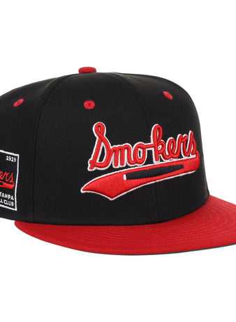 The EFF Tampa Smokers NLB Black and Red Fitted Ballcap features “Tampa Smokers” embroidered in red and white cursive on the front, with a side patch reading “Smokers Tampa Baseball Club 1919,” honoring the historic Florida International League.