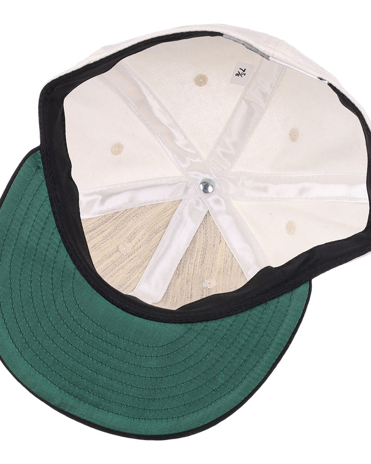 An inside view of the EFF Thespians 1919 Vintage Ballcap: features a green brim, white stitched inner panels, and a black sweatband—an authentic reproduction of a classic baseball cap.
