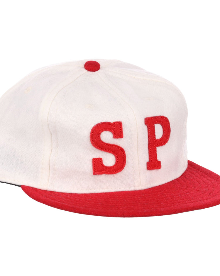 The EFF Nebraska State Prison 1923 Vintage Ballcap is a wool cap with a white crown, red brim and button, and bold red SP letters—an authentic reproduction of the original prison team hat.