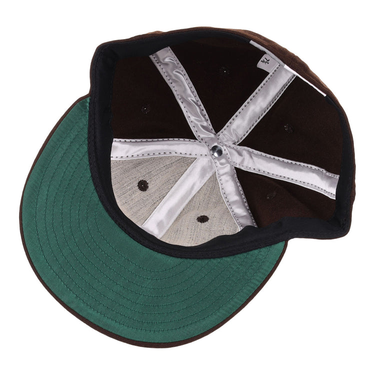 An upside-down view of the EFF Independent Subway System 1939 Vintage Ballcap showcases its green visor, black interior panels, silver inner lining, and black stitched eyelets—classic details from the original New York transit hat design.