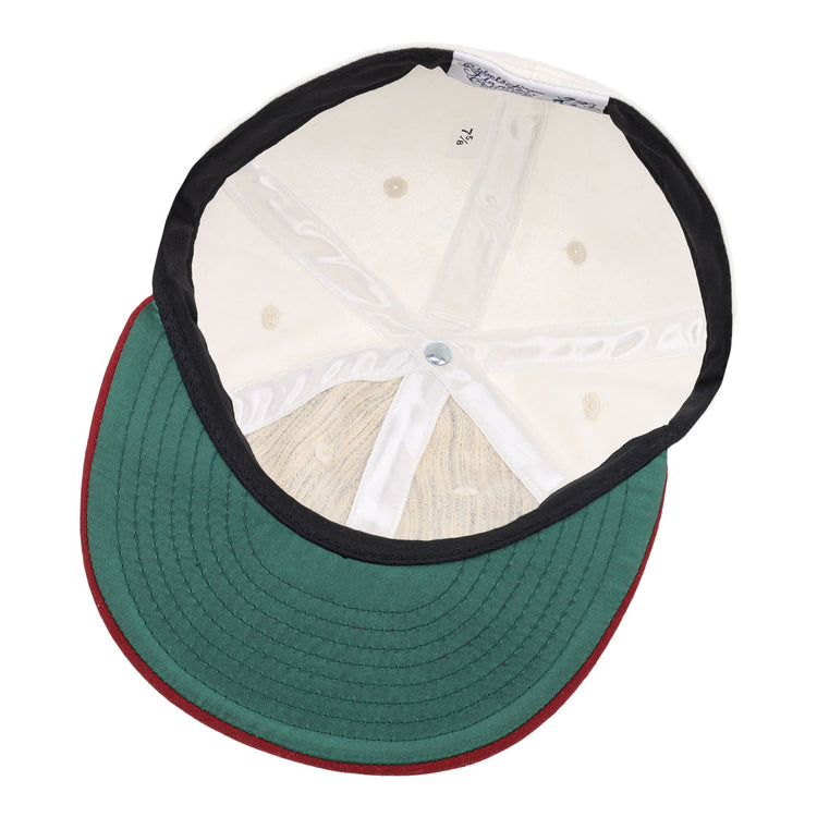 The image shows the inside of the EFF University of Alabama 1950 Vintage Ballcap, featuring a green brim with red edge, white interior panels, black lining, visible size label, and detailed top button stitching.