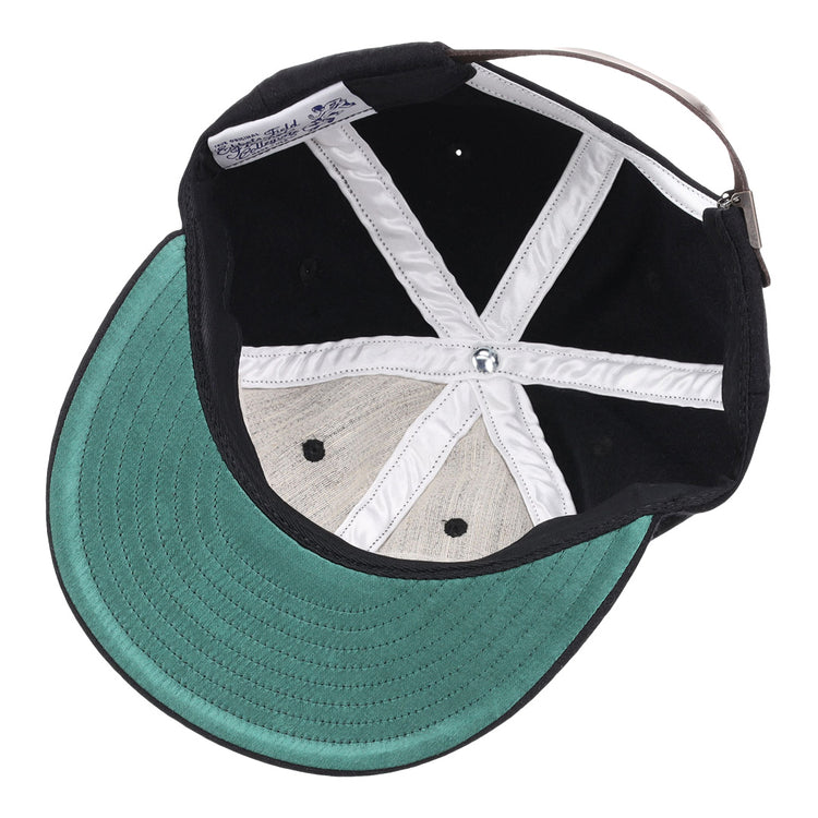 The image shows the inside of an EFF Grambling State University 1963 Vintage Ballcap with a black wool exterior, green underbrim, white stitched “X” panels, and an adjustable strap—a perfect HBCU collectible.