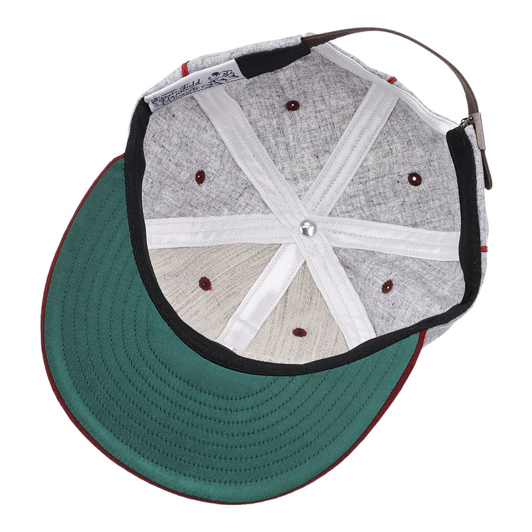 A look inside the EFF Loyola Marymount University 1939 Vintage Ballcap shows its green underbrim, red stitching, adjustable brown strap, visible internal seams, and ventilation holes—classic features of this historic hat.