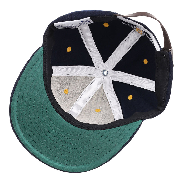 The image shows the inside view of the EFF University of North Carolina Greensboro Mascot Vintage Ballcap, featuring a navy wool build, green brim, white stitching, yellow eyelets, and an adjustable brown back strap.