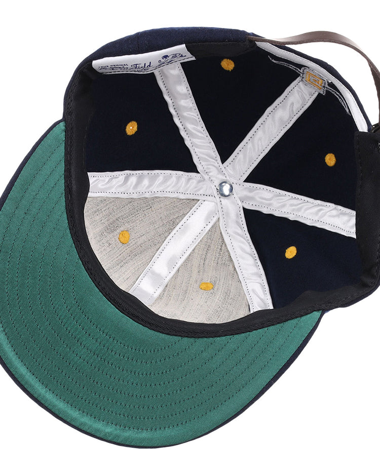 The image shows the inside view of the EFF University of North Carolina Greensboro Mascot Vintage Ballcap, featuring a navy wool build, green brim, white stitching, yellow eyelets, and an adjustable brown back strap.