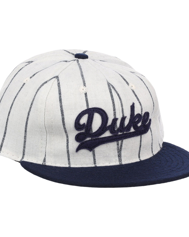 The EFF Duke University Pinstripe Script Vintage Ballcap features thin navy pinstripes on white, a navy brim, and Duke embroidered in navy script for a classic baseball look.