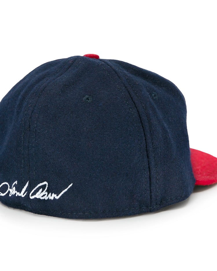 The Ebbets Field Flannels Hank Aaron 1957 Signature Series Ballcap is a vintage-style navy wool cap with a red brim and Hank Aaron’s signature embroidered in white on the back, made in the USA.