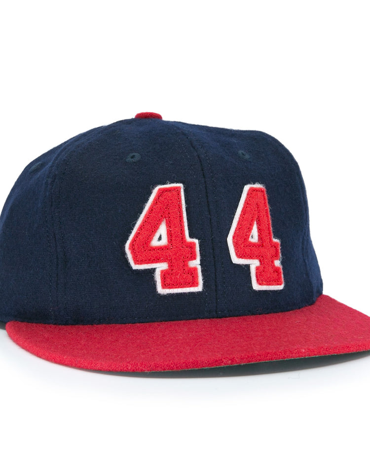 The Ebbets Field Flannels Hank Aaron 1957 Signature Series Ballcap is a vintage-style wool cap in navy with a red brim and bold red-and-white “44” on the front, inspired by baseball legends and proudly made in the USA.