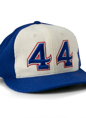 The Hank Aaron 1973 Signature Series Ballcap by Ebbets Field Flannels is a vintage-style wool cap, made in the USA, featuring blue/white panels and “44” in blue and red outlined on the front.