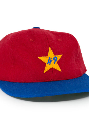 The EFF Alaska Goldpanners 1964 Vintage Ballcap is a red cap with a blue brim, yellow star, and blue “49” embroidered on the front—an authentic reproduction of the classic original.