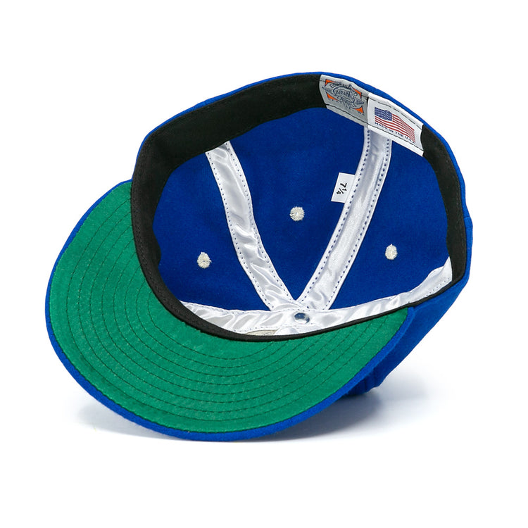 The Almendares Alacranes 1947 Vintage Ballcap by Ebbets Field Flannels features a blue wool exterior, green undervisor, white satin lined interior with seams, tag labels, and black trim around the inner edge.
