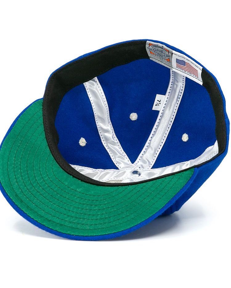 The Almendares Alacranes 1947 Vintage Ballcap by Ebbets Field Flannels features a blue wool exterior, green undervisor, white satin lined interior with seams, tag labels, and black trim around the inner edge.