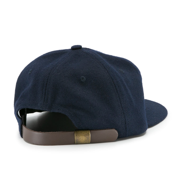 The Ebbets Field Flannels Auburn University 1966 Vintage Ballcap in navy features a brown adjustable leather strap with a brass buckle—an officially licensed college vault wool cap viewed from the back.