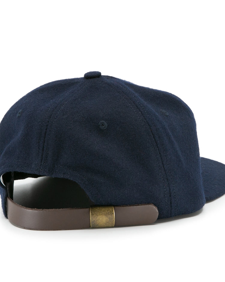 The Ebbets Field Flannels Auburn University 1966 Vintage Ballcap in navy features a brown adjustable leather strap with a brass buckle—an officially licensed college vault wool cap viewed from the back.