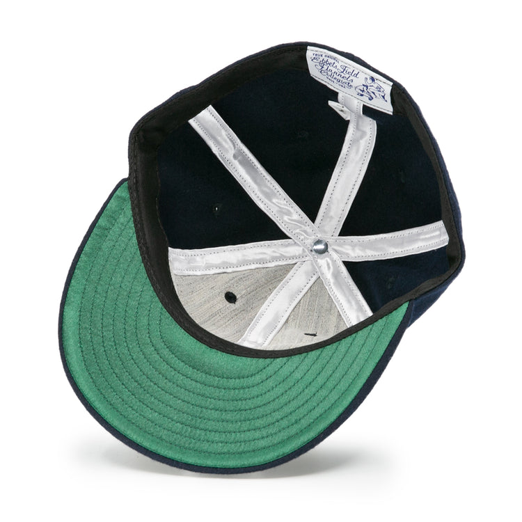 The underside of the Auburn University 1966 Vintage Ballcap by Ebbets Field Flannels features a green bill, white stitched panels, silver top button, and an interior Auburn University ballcap tag.