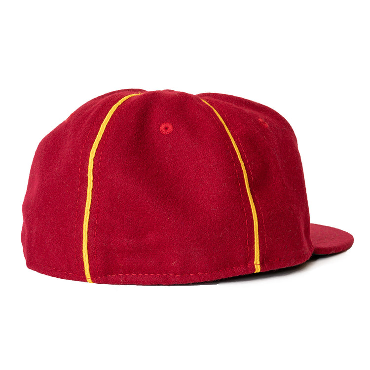 The Ebbets Field Flannels Club Bacardi 1930 Vintage Ballcap is a red wool cap with a flat brim and two yellow stripes from brim to back, inspired by the Cuban National Amateur League. Shown from the back.