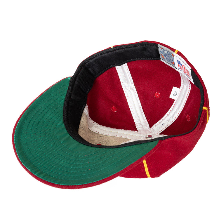 A red Club Bacardi 1930 Vintage Ballcap by Ebbets Field Flannels is shown upside down, displaying the green underside of the brim, white inner lining, and a size tag marked 7 1/4 next to an American flag label.