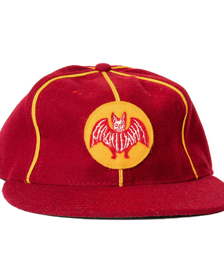 The Ebbets Field Flannels Club Bacardi 1930 Vintage Ballcap is a genuine wool cap in red with yellow piping and a circular front patch featuring an embroidered red bat—a tribute to the Cuban National Amateur League.