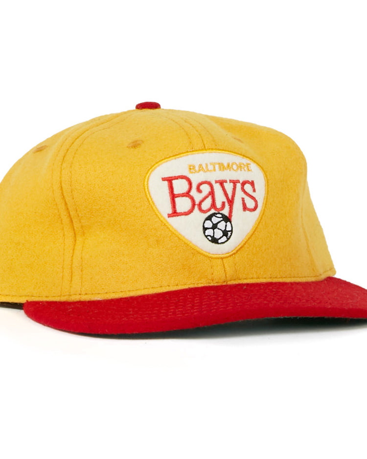 The Baltimore Bays 1967 Vintage Ballcap by EFF features a yellow crown, red brim, and a white front patch with “Baltimore Bays” text and soccer ball graphic, inspired by the authentic 1967 design.