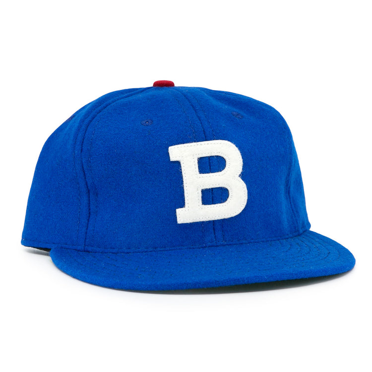 The EFF Los Barbudos 1959 Vintage Ballcap is a genuine wool blue baseball hat with a white B on the front and a small red button on top, shown against a white background.