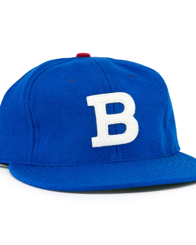 The EFF Los Barbudos 1959 Vintage Ballcap is a genuine wool blue baseball hat with a white B on the front and a small red button on top, shown against a white background.