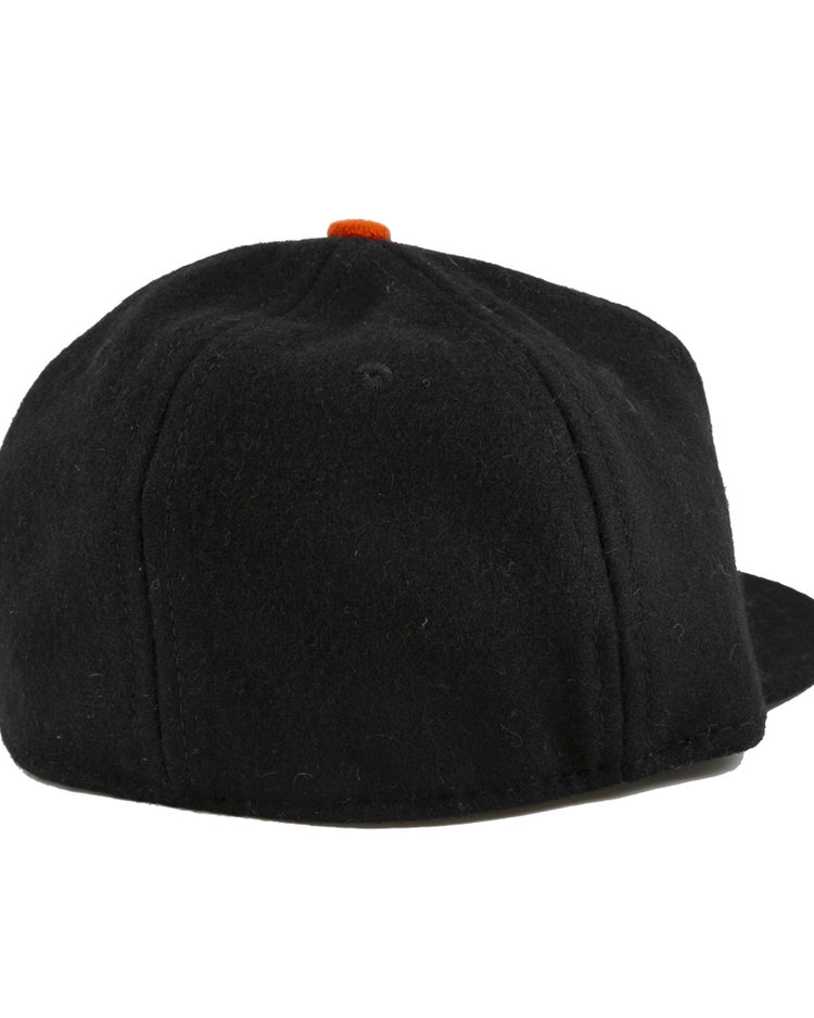 The EFF Bisbee-Douglas Copper Kings 1951 Vintage Ballcap is a classic wool hat, seen from the back with no visible logos or designs, featuring a small orange top button—an understated nod to vintage ballcap styles.