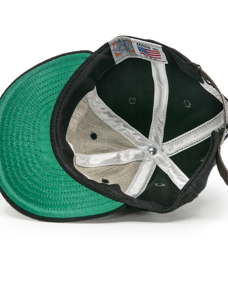 The image shows the inside of an EFF Bisbee-Douglas Copper Kings 1951 Vintage Ballcap, featuring a green undervisor, white fabric strips, and a Made in USA tag sewn into the inner band.