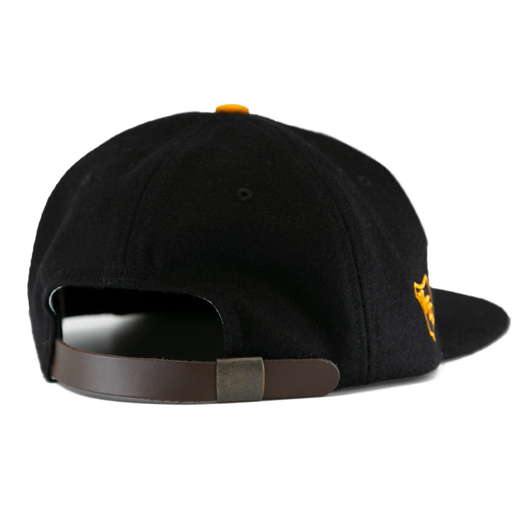 The EFF Brandon Wheat Kings 1955 Vintage Ballcap is a black wool cap shown from the back, with a brown adjustable leather strap, metal clasp, and yellow side embroidery—ideal for vintage hockey hat fans.