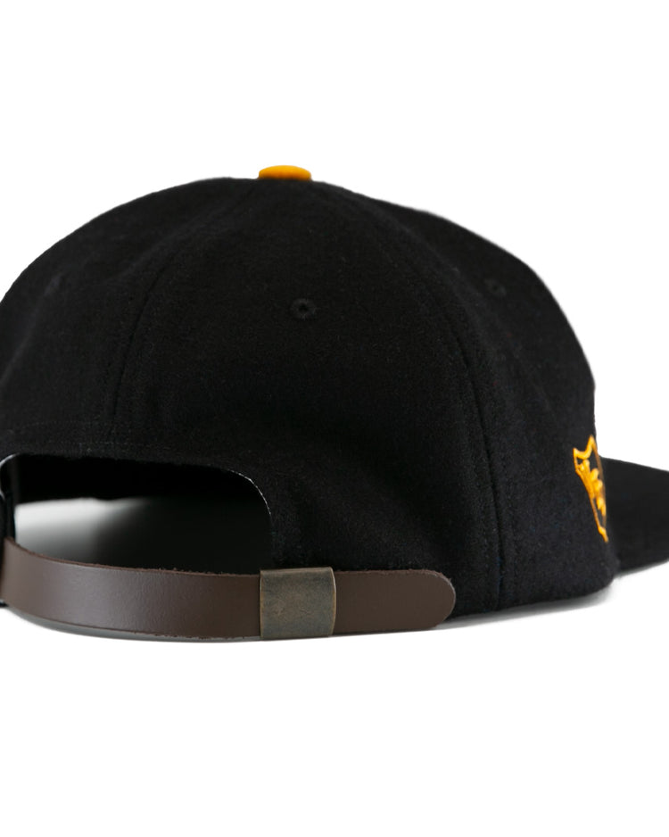 The EFF Brandon Wheat Kings 1955 Vintage Ballcap is a black wool cap shown from the back, with a brown adjustable leather strap, metal clasp, and yellow side embroidery—ideal for vintage hockey hat fans.