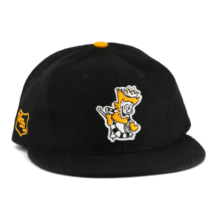 The EFF Brandon Wheat Kings 1955 Vintage Ballcap is a black wool hat inspired by classic hockey styles, featuring a yellow and white crowned cartoon lion embroidered on the front and a small yellow shield emblem.