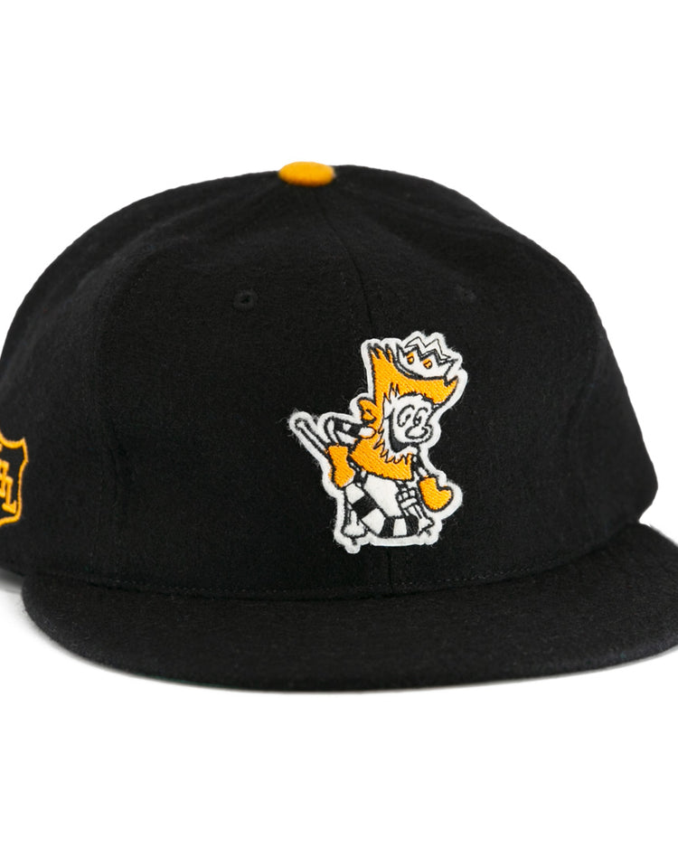The EFF Brandon Wheat Kings 1955 Vintage Ballcap is a black wool hat inspired by classic hockey styles, featuring a yellow and white crowned cartoon lion embroidered on the front and a small yellow shield emblem.