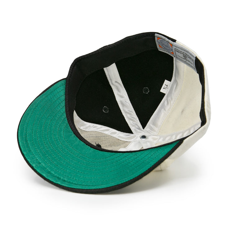 The image shows the inside of an EFF Bacharach Giants 1924 Vintage Ballcap, featuring a green brim, white interior panels, black lining, visible stitching, and a size tag.